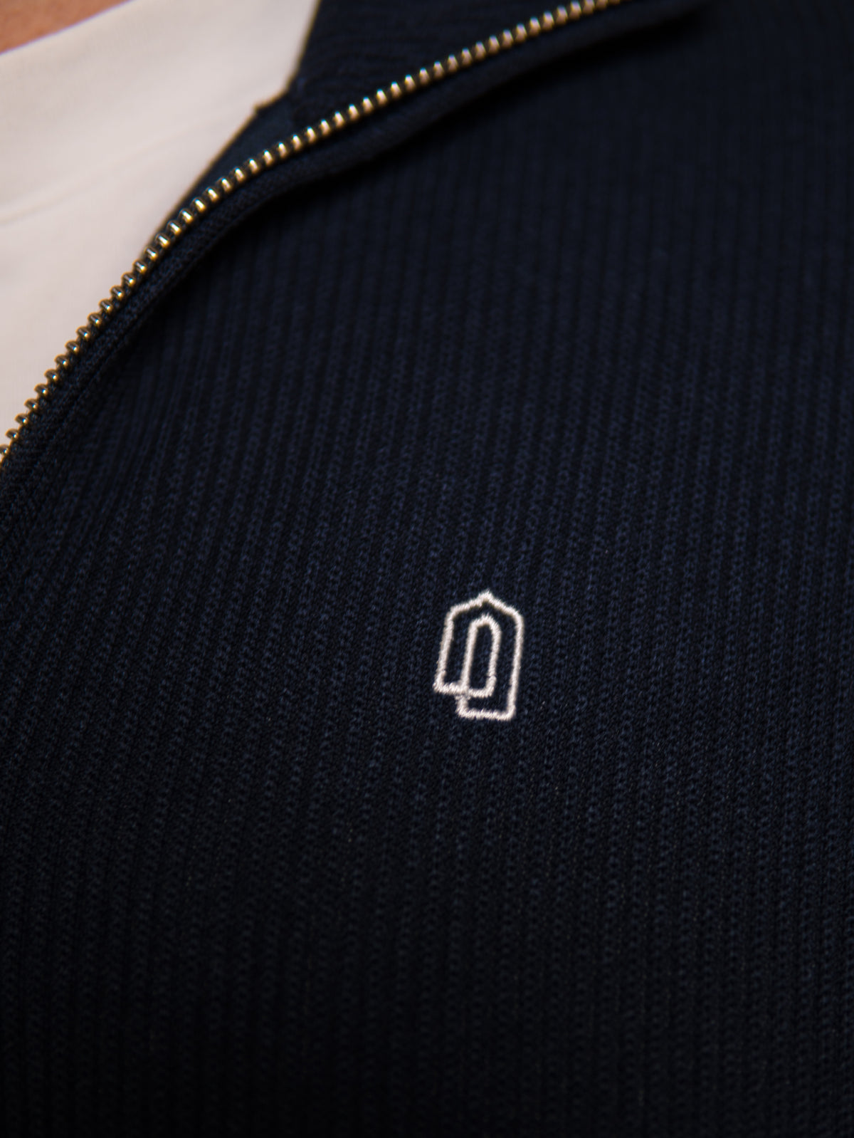 Navy Signature Quarter Zip Thobe, embroidered logo close-up